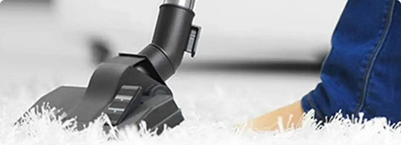 Close-up of a professional vacuuming a white carpet in Wendell.